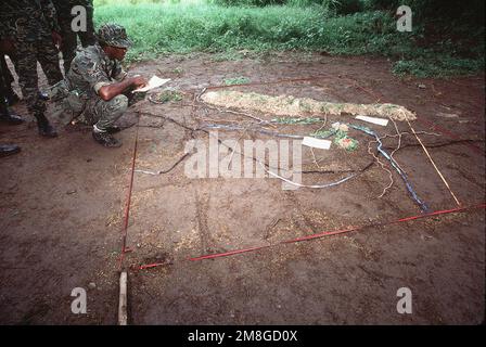 Un soldato della Guyana Defense Forces consulta una mappa tattica di soccorso improvvisata durante TRADEWINDS '92, un esercizio congiunto tra undici paesi caraibici, il Regno Unito e gli Stati Uniti. Subject Operation/Series: TRADEWINDS '92 Nazione: Barbados(BRB) Foto Stock