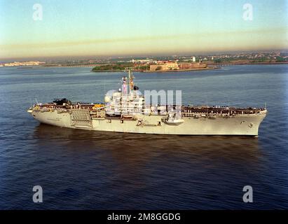 Una vista aerea a dritta della nave anfibia USS GUADALCANAL (LPH-7) passando per l'Ellis Island Memorial Immigration Center quando la nave arriva a New York City per la Fleet Week '92. Base: New York Harbor Stato: New York (NY) Paese: Stati Uniti d'America (USA) Foto Stock