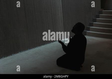 Uomo musulmano che prega nella moschea alzando le mani. Silhouette di un uomo che prega in moschea. Foto di sfondo Ramadan o islamica. Istanbul Turkiye - 11 Foto Stock