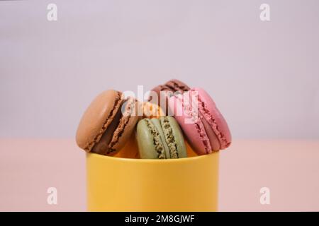 macaron di diversi colori e sapori su sfondo con colori pastello Foto Stock