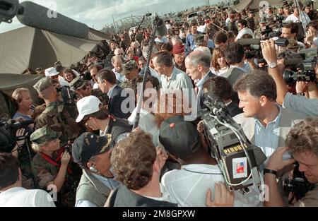 I membri dei media si riuniscono intorno al presidente George Bush mentre incontra il personale militare e i civili durante il suo tour nella regione. Bush si trova in Florida per valutare i danni e osservare gli sforzi di soccorso in caso di disastro subito dopo l'uragano Andrew. Base: Homestead Air Force base Stato: Florida (FL) Paese: Stati Uniti d'America (USA) Foto Stock