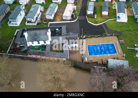 Stourport su Severn, Worcestershire, 14 gennaio 2023 - i siti di carovane lungo il fiume Severn a Stourport su Severn sono stati inondati a causa dell'aumento dell'acqua dopo che il fiume ha scoppiato le sue rive. Una fila di case sul fiume e una piscina per il tempo libero del parco sono mantenute asciutte a causa delle barriere alluvionali e delle pompe dell'acqua. Si prevede che il fiume si innalzi ulteriormente e raggiunga il picco la domenica mattina presto. Credito: Interrompi stampa Media/Alamy Live News Foto Stock