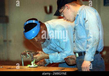 Hull Technician Fireman (HTFN) Clarke, Left, and Hull Technician Third Class Schmitt esegue la saldatura a gas di una nuova linea di raffreddamento ad acqua salata presso l'impianto di manutenzione intermedia delle navi. Base: Naval Station, New York Stato: New York (NY) Paese: Stati Uniti d'America (USA) Foto Stock