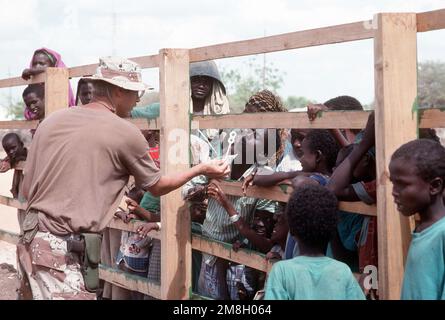 Robert Sasek, IL COMPAGNO DEL FOTOGRAFO CAPO, intrattiene un gruppo di bambini somali che osservano i membri del Battaglione Navale per la costruzione 1 (NMCB-1) che lavorano in un parco giochi scolastico. NMCB-1 sta lavorando per migliorare la scuola come parte di un progetto di azione civile durante L'OPERAZIONE multinazionale di soccorso RIPRISTINARE LA SPERANZA. Oggetto operazione/Serie: RIPRISTINO SPERANZA Paese: Somalia (SOM)