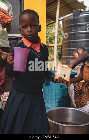 23.05.2022 Mwanza, Tanzania - i bambini che gustano una tazza di tè a pranzo nella scuola rurale Foto Stock