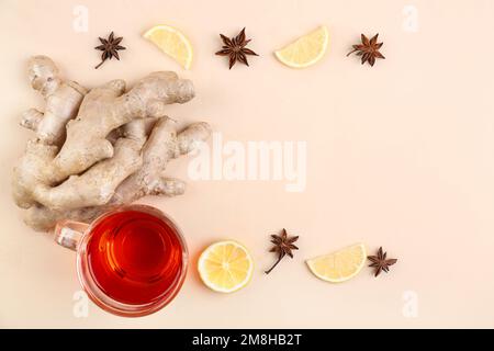 Radici di zenzero, tazza di tè nero, fettine di limone e anice su sfondo beige Foto Stock