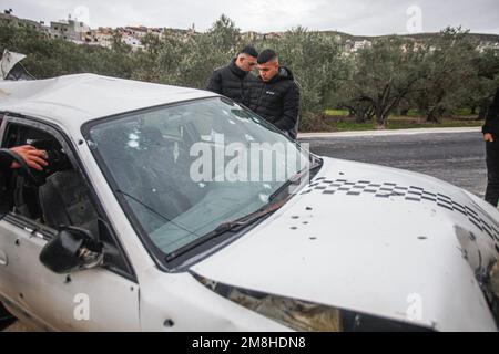 Jenin, Palestina. 14th Jan, 2023. I palestinesi ispezionano l'auto in cui due palestinesi sono stati uccisi dall'esercito israeliano durante il loro inseguimento, dopo aver aperto il fuoco su un posto militare, nella città di Jaba, vicino a Jenin, nella Cisgiordania occupata. Credit: SOPA Images Limited/Alamy Live News Foto Stock