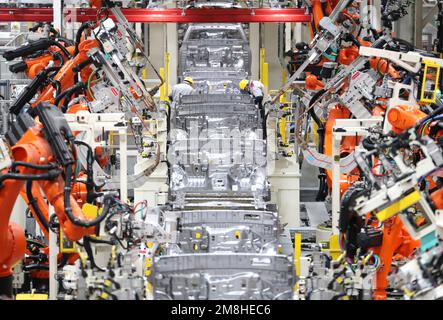 QINGDAO, CINA - 14 GENNAIO 2023 - i lavoratori salda in un workshop di produzione presso la sede centrale di Qingdao della fabbrica di automobili di Pechino a Qingdao, S. Foto Stock