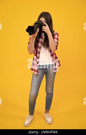 Fotografo ragazza adolescente con una fotocamera reflex digitale. Fotocamera digitale per bambini. Bambino che fotografa. Scuola di fotografia. Bambino fotografo principiante. Foto Stock