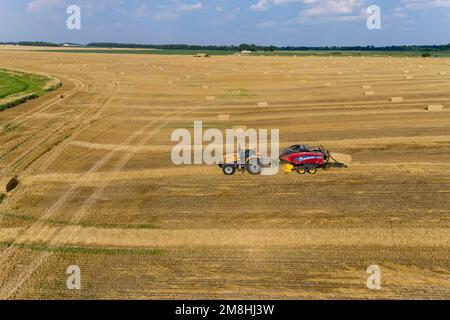 63801-17709 Vista aerea di grandi balle quadrate di paglia di grano nel campo e paglia di imballaggio del trattore Clay Co.. IL Foto Stock