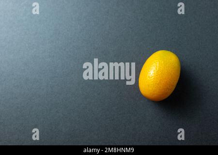 Cumquat o kumquat primo piano su sfondo grigio. Foto Stock