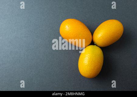 Cumquat o kumquat primo piano su sfondo grigio. Foto Stock