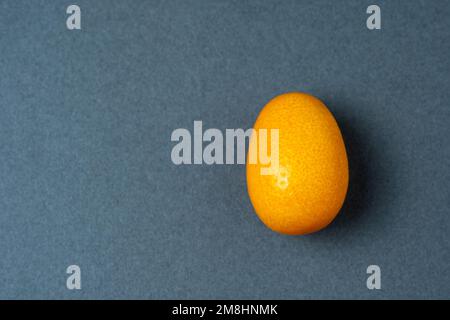 Cumquat o kumquat primo piano su sfondo grigio. Foto Stock