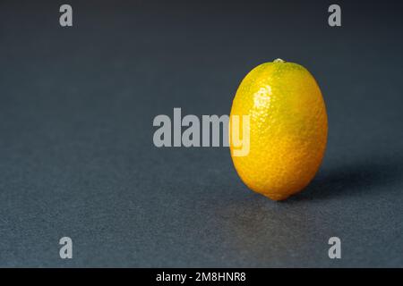 Cumquat o kumquat primo piano su sfondo grigio. Foto Stock