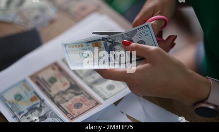 Il criminale taglia le fatture del dollaro con le forbici stampate sul primo piano della stampante Foto Stock