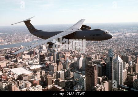 Una vista aria-aria lato destro di una Ala 438th Airlift, C-141 Starlifter che sorvola il quartiere finanziario del centro di Philadelphia. Il modello C-141, tail #40616, offre capacità di sollevamento a lungo raggio per Air Mobility Command. Data esatta dell'acquisizione sconosciuta. Base: McGuire Air Force base Stato: New Jersey (NJ) Paese: Stati Uniti d'America (USA) Foto Stock