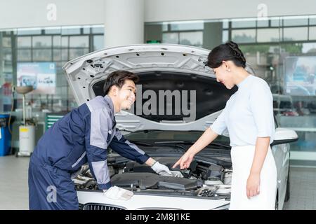 Riparazione di meccanici del personale con il cliente Foto Stock