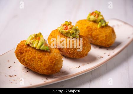 Crocchette di avocado guacamole. Porzione di impasto ottenuta da una salsa densa come il bechamel e una mincemeat di vari ingredienti o verdure. Foto Stock