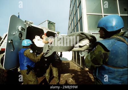 I primi pazienti feriti arrivano dal portatore di personale blindato (APC) al terminal dell'aeroporto di Sarajevo dopo che un mortaio esploso ha colpito il mercato Markale uccidendo più di 63 persone e ferendo altri 206. Oggetto operazione/Serie: FORNIRE PROMESSA base: Sarajevo Paese: Bosnia e/i Erzegovina (BIH) Foto Stock