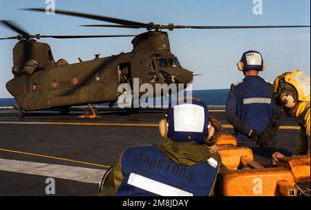 Il personale del ponte di volo è in attesa mentre l'equipaggio di un US Army MH-47D Chinook elicottero a medio sollevamento del 2nd Battaglione, 160th Special Operation Aviation Regiment riscaldare i motori dell'aeromobile in preparazione per il decollo a bordo della portaerei nucleare USS GEORGE WASHINGTON (CVN-73) durante l'esercizio Fleet 2-94. Oggetto/Serie: ESERCIZIO FLOTTA 2-94 Paese: Oceano Atlantico (AOC) Foto Stock