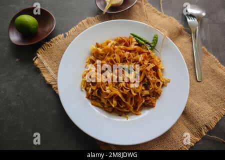 Kwetiau goreng è cinese indonesiano mescolato piatto piatto di pasta di riso fatto da kwetiau, mescolato fritto in olio da cucina con aglio, cipolla, manzo, pollo, Foto Stock