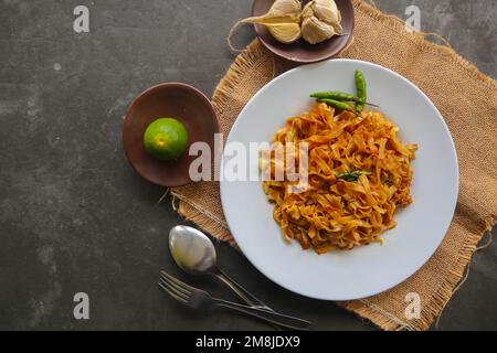 Kwetiau goreng è cinese indonesiano mescolato piatto piatto di pasta di riso fatto da kwetiau, mescolato fritto in olio da cucina con aglio, cipolla, manzo, pollo, Foto Stock