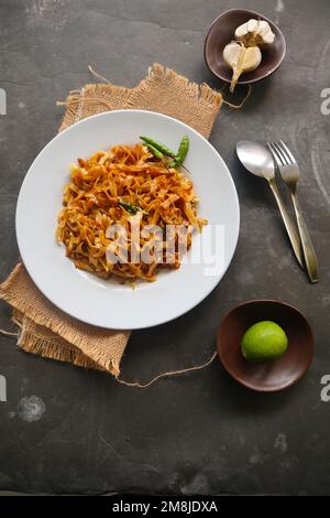 Kwetiau goreng è cinese indonesiano mescolato piatto piatto di pasta di riso fatto da kwetiau, mescolato fritto in olio da cucina con aglio, cipolla, manzo, pollo, Foto Stock