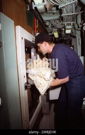 SPECIALISTA in pasticci terza Classe (MS3) James Frame è mostrato che scompaia cibo per il pasto successivo dal deposito refrigerato a bordo del sottomarino di attacco nucleare USS NORFOLK (SSN-714). Paese: Chesapeake Bay Foto Stock