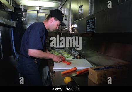 SPECIALISTA dei pasticci terza Classe (MS3) James Frame prepara insalate per cena per i membri della sala di guardia a bordo del sottomarino d'attacco nucleare USS NORFOLK (SSN-714). Paese: Chesapeake Bay Foto Stock