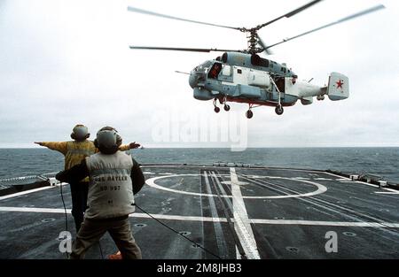 Un controllore del ponte di volo sul cacciatorpediniere USS HAYLER (DD-997) segnala ad un elicottero russo Ka-27PS Helix-D che è libero di liberare il ponte di volo per un volo libero dopo il decollo dalla nave. L'elicottero era appena diventato il primo aereo russo ad atterrare sul cacciatorpediniere durante il BALTOPS 94. Il HAYLER è il fiore all'occhiello per l'operazione "94" del Baltico. Oggetto/Serie: BALTOPS 94 Paese: Mar Baltico Foto Stock