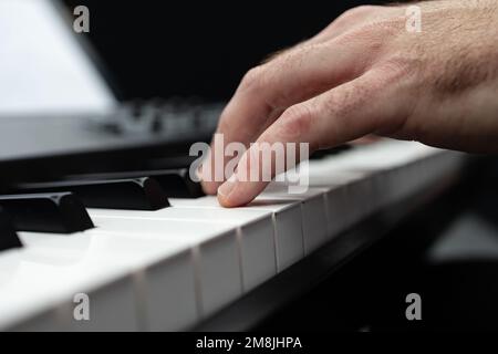 Un primo piano di mani che suonano su un sintetizzatore Foto Stock