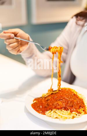 Giovane donna gustare la pasta Foto Stock