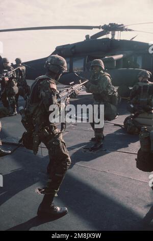 Philip Mims, sergente dell'esercito DEGLI STATI UNITI, di prima classe, di Bravo Company, 2nd battaglione, 22nd Brigata di fanteria leggera, Fort Drum, New York, guida un gruppo nella formazione di disturbo civile mentre si è in transito ad Haiti a bordo della USS DWIGHT D. EISENHOWER (CVN 69), a sostegno dell'operazione SOSTENERE LA DEMOCRAZIA. Un elicottero UH-60 Black Hawk può essere visto sullo sfondo. Oggetto/Serie: SOSTENERE LA DEMOCRAZIA base: USS Dwight D Eisenhower (CVN 69) Foto Stock