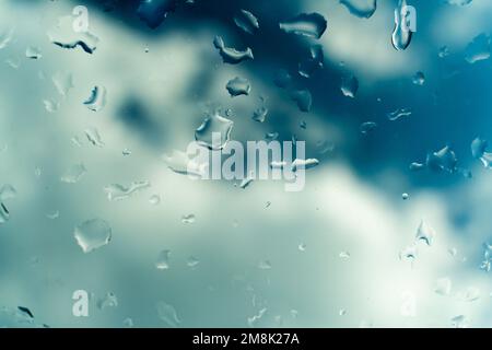 Gocce d'acqua sul vetro contro il cielo blu. Screensaver di sfondo della vista finestra. Posiziona per banner di testo. Foto Stock