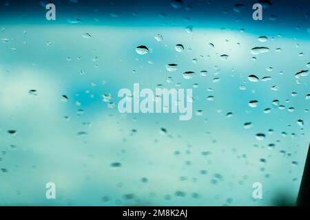 Gocce d'acqua sul vetro contro il cielo blu. Screensaver di sfondo della vista finestra. Posiziona per banner di testo. Foto Stock