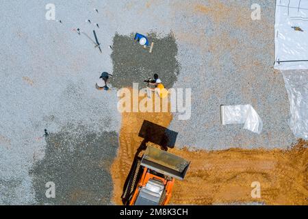 Una benna per escavatore utilizzata prima della fondazione del calcestruzzo viene versata sul sito dell'edificio per livellare la ghiaia Foto Stock