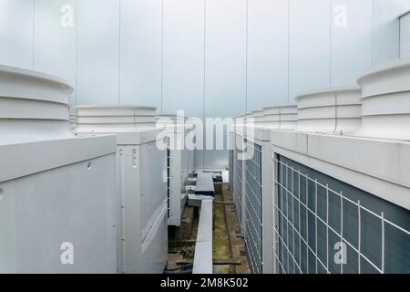 Una vista in primo piano di un gran numero di moderni condizionatori d'aria centrali fuori dall'edificio Foto Stock