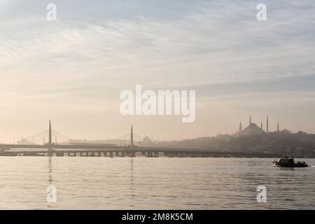 Istanbul, Turchia - Gennaio, 2023: Vista all'alba della Moschea Suleymaniye e del Corno d'Oro metro ponte skyline della città con una barca a vela Foto Stock