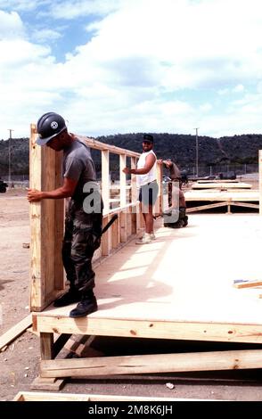 US Navy Seabees da Naval Mobile Construction Battalion 4 (NMCB-4) e carpentieri migranti cubani costruiscono strutture di tenda a sostegno duro per il villaggio Bravo a Camp Bulkeley. La costruzione è una soluzione nel tentativo di migliorare la qualità della vita dei migranti. Subject Operation/Series: SEA SIGNAL base: Guantánamo Bay Paese: Cuba (CUB) Foto Stock