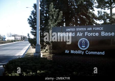 Una vista a lungo raggio del cancello principale con il cartello di base in primo piano. Base: Fairchild Air Force base Stato: Washington (WA) Paese: Stati Uniti d'America (USA) Foto Stock