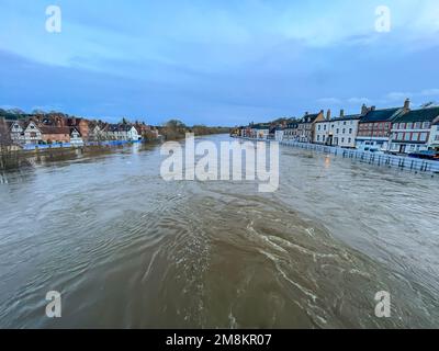 Bewdley, Regno Unito. 14th gennaio 2023. Sabato sera i lavoratori dell'Agenzia dell'ambiente si fermano a tutte le fermate per garantire la sicurezza e la protezione continua dei residenti e delle aziende di Bewdley. Mentre l'alluvione del fiume Severn del Worcestershire raggiunge livelli pericolosi, il team di gestione delle alluvioni dell'Environment Agency sa che è ora il momento cruciale per installare le barriere finali. Questo è tutto - sono alla loro massima altezza. Credit: Lee Hudson/Alamy Live News Foto Stock