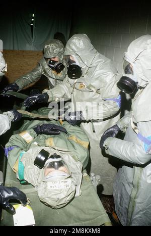 Presso il punto di raccolta delle vittime per il 43rd Air Refueling Group per il dispiegamento di farmaci e medici (indossando nucleare-biologico-chimico, NBC, tute protettive e maschere) del 341st Medical Group lavorano rapidamente per valutare e trattare un aviatore ferito su una barella dopo un attacco simulato. I 'feriti', come AIRMAN 1st Classe Matthew Legge, 43rd Logistics Squadron sono costituiti da lesioni realistiche e successivamente apposto sulla linea di volo durante gli attacchi simulati. AIRMAN e il personale di altre unità di supporto della 341st Missile Wing partecipano al 43rd Air Refuelling G. Foto Stock