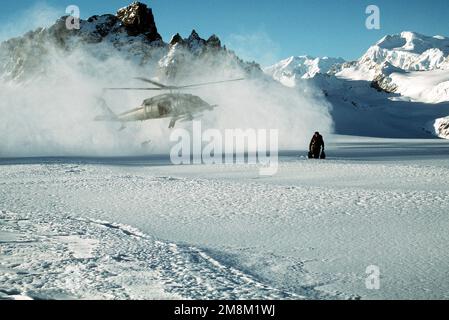 Parasalvemen del 210th Rescue Squadron schierati da un elicottero Pavehawk HH-60G in un campo di neve in alto sulle montagne sopra Anchorage per un esercizio di allenamento per salvare un pilota abbattuto. Base: Anchorage Stato: Alaska (AK) Paese: Stati Uniti d'America (USA) Foto Stock