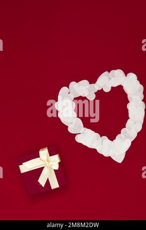 Cuore bianco di carte e scatola regalo su sfondo Viva Magenta Foto Stock