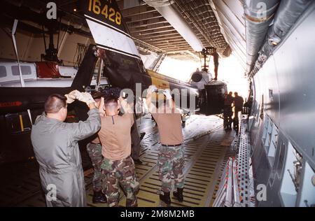 I membri di Alpha Company 2/228th Aviation Regiment, Willow Grove Naval Air Station, Pennsylvania, assistono nell'offload dell'elicottero UH-1 da un aereo galassico C-5 per partecipare a Roving Sands '96, il più grande esercizio annuale di addestramento congiunto per la difesa aerea dell'esercito statunitense. Soggetto operativo/Serie: ROVING SANDS '96 base: Biggs Army Air Field, El Paso Stato: Texas (TX) Paese: Stati Uniti d'America (USA) Foto Stock