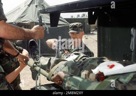 I medici di campo dell'esercito del Connecticut National Guard's 405th Combat Support Hospital, situato nel campo base Oro Grande, New Mexico durante il "96" di Rosing Sands, lavorano rapidamente per trasportare un paziente simulato all'ospedale dove medici e infermieri cureranno il paziente come parte di un esercizio di massa. Soggetto operativo/Serie: ROVING SANDS '96 base: Oro Grande base Camp Stato: New Mexico (NM) Paese: Stati Uniti d'America (USA) Foto Stock