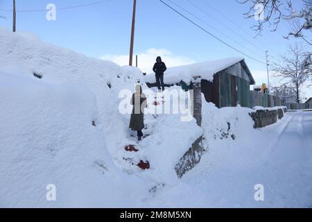 Srinagar, India. 14th Jan, 2023. (1/14/2023) gli abitanti di Kashmiri camminano su un'area coperta di neve dopo una forte nevicata nella zona di Baramulla del Kashmir. Le autorità di Jammu e Kashmir hanno lanciato un avvertimento a valanga per 10 distretti che hanno assistito a nevicate da moderate a pesanti nelle ultime 48 ore. (Foto di Sajad Hameed/Pacific Press/Sipa USA) Credit: Sipa USA/Alamy Live News Foto Stock