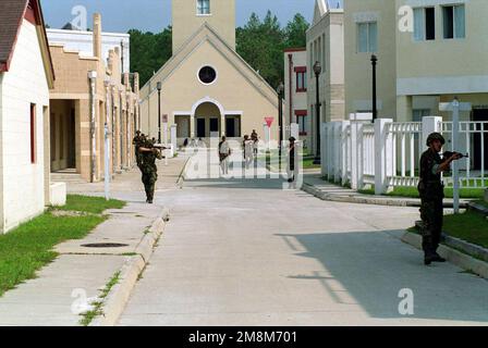 I membri della US Marine Corps Company 4 pattugliano una città durante l'esercizio di addestramento situazionale -2, operazioni militari in terreno urbano, LA COOPERATIVA OSPREY '96. La cooperativa Osprey '96 è un esercizio sponsorizzato dal comando Atlantico degli Stati Uniti, che sarà condotto dalle forze Marine Atlantic, nell'agosto 1996 a Camp Lejeune, North Carolina. La cooperativa Osprey, nell'ambito del programma partenariato per la pace, fornirà una formazione sull'interoperabilità nelle operazioni di mantenimento della pace e umanitarie secondo gli standard NATO/IFOR, con particolare attenzione alle competenze individuali e collettive. Operazione/Serie oggetto: COOPERATIVA OSPREY Foto Stock