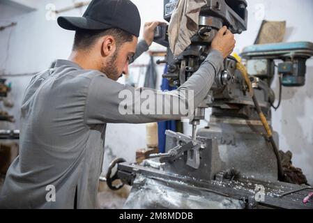 Un fabbro che lavora su un revolver in una fabbrica di armi, Peshawar, Pakistan Foto Stock