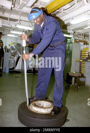 US Navy Aviation Support Equipment Technician AIRMAN (ASAN) Xavier Campbell fissa uno pneumatico piatto del trattore di velivoli a bordo della portaerei a propulsione nucleare USS NIMITZ (CVN 68). Il NIMITZ è attualmente dispiegato nel Golfo Persico a sostegno dell'operazione SOUTHERN WATCH, 27 gennaio 1998. Soggetto operativo/Serie: SOUTHERN WATCH base: USS Nimitz (CVN 68) Foto Stock